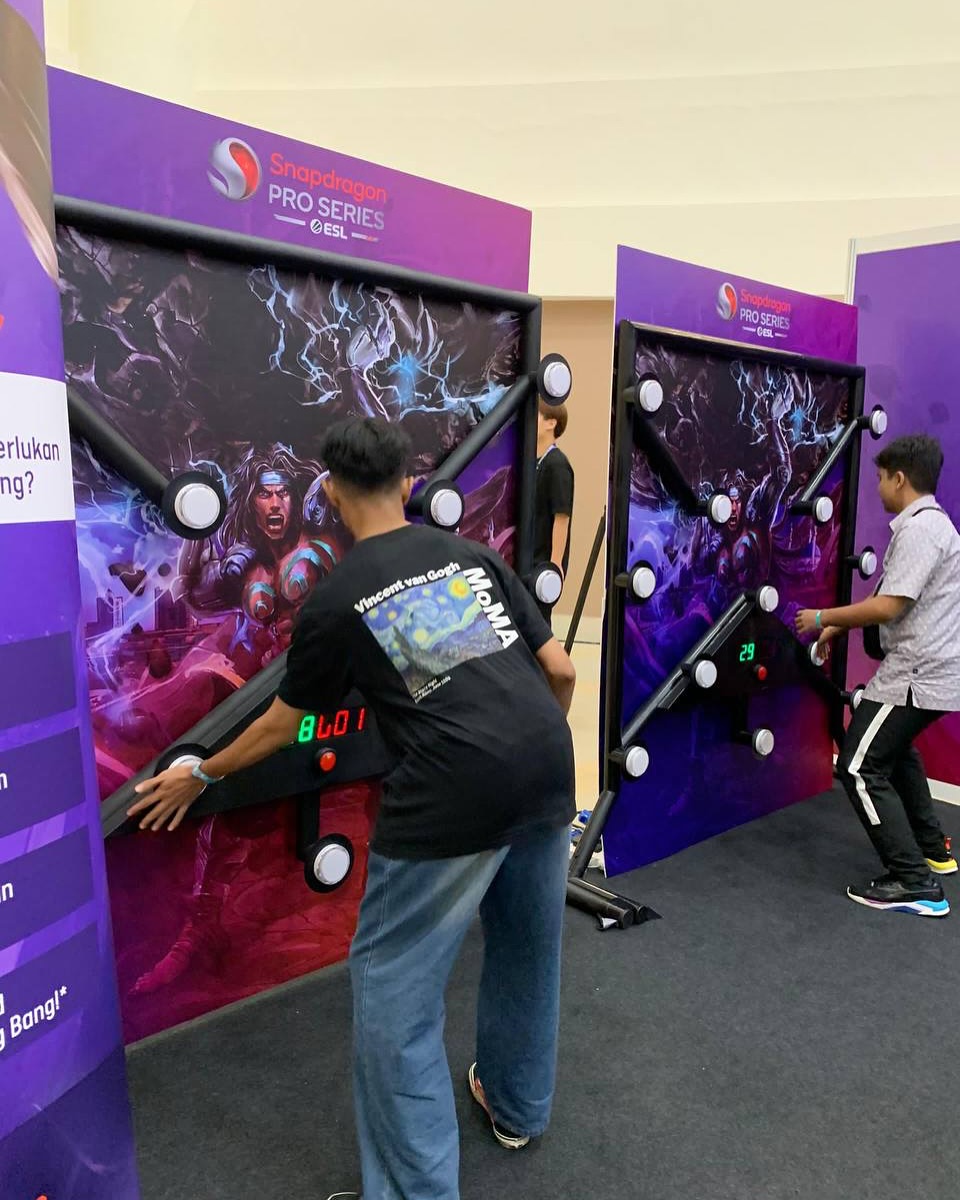 Player hitting illuminated targets in Batak reaction game, high energy party entertainment setup