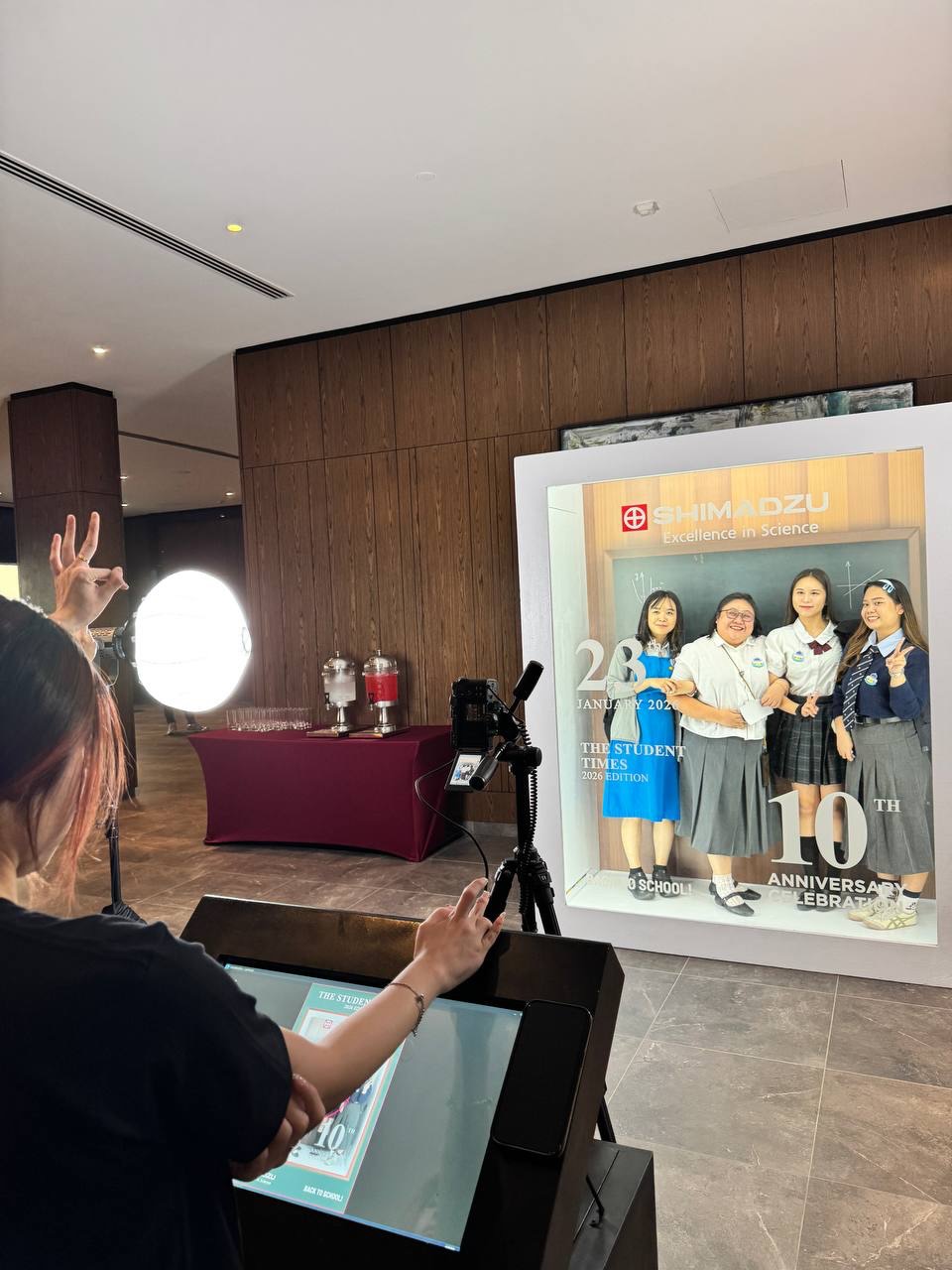 Guests posing in magazine style photoshoot setup with branded cover frame at event