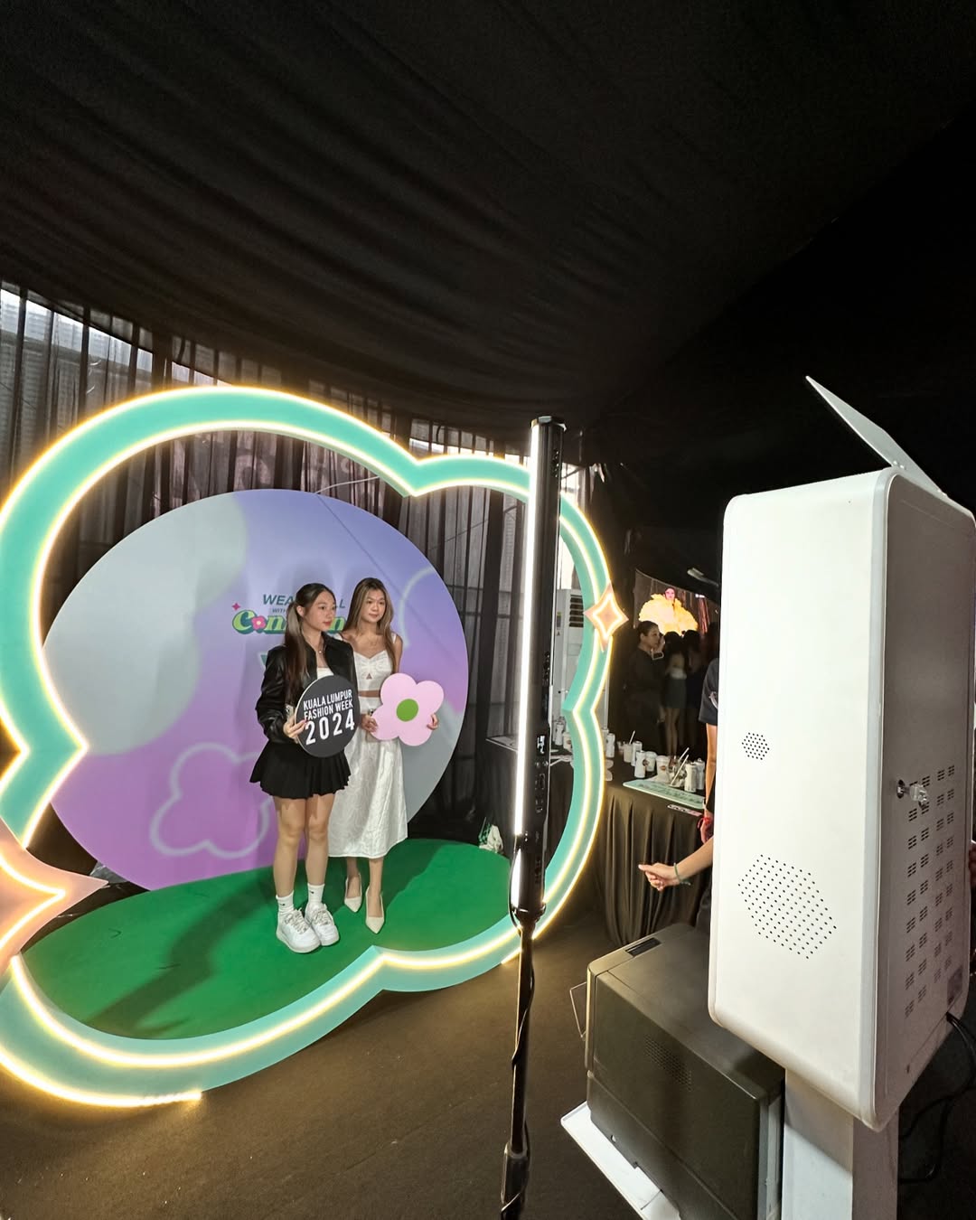 Event guests taking photos at premium selfie booth with instant prints and props